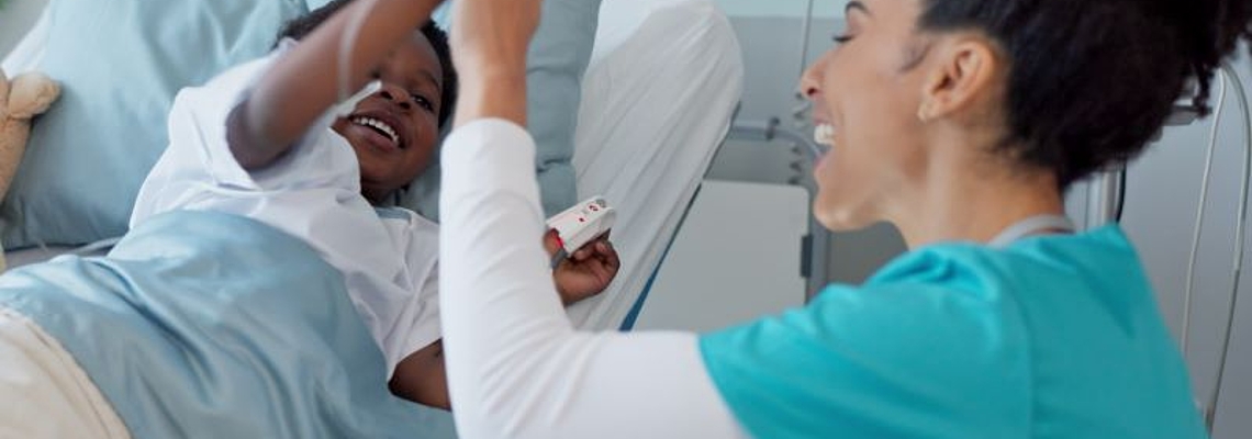 Eine Krankenschwester und ein Kind als Patient geben sich ein fröhliches High-Five