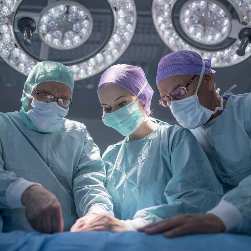 3 Chirurgen operieren einen Patienten in einem Operationssaal