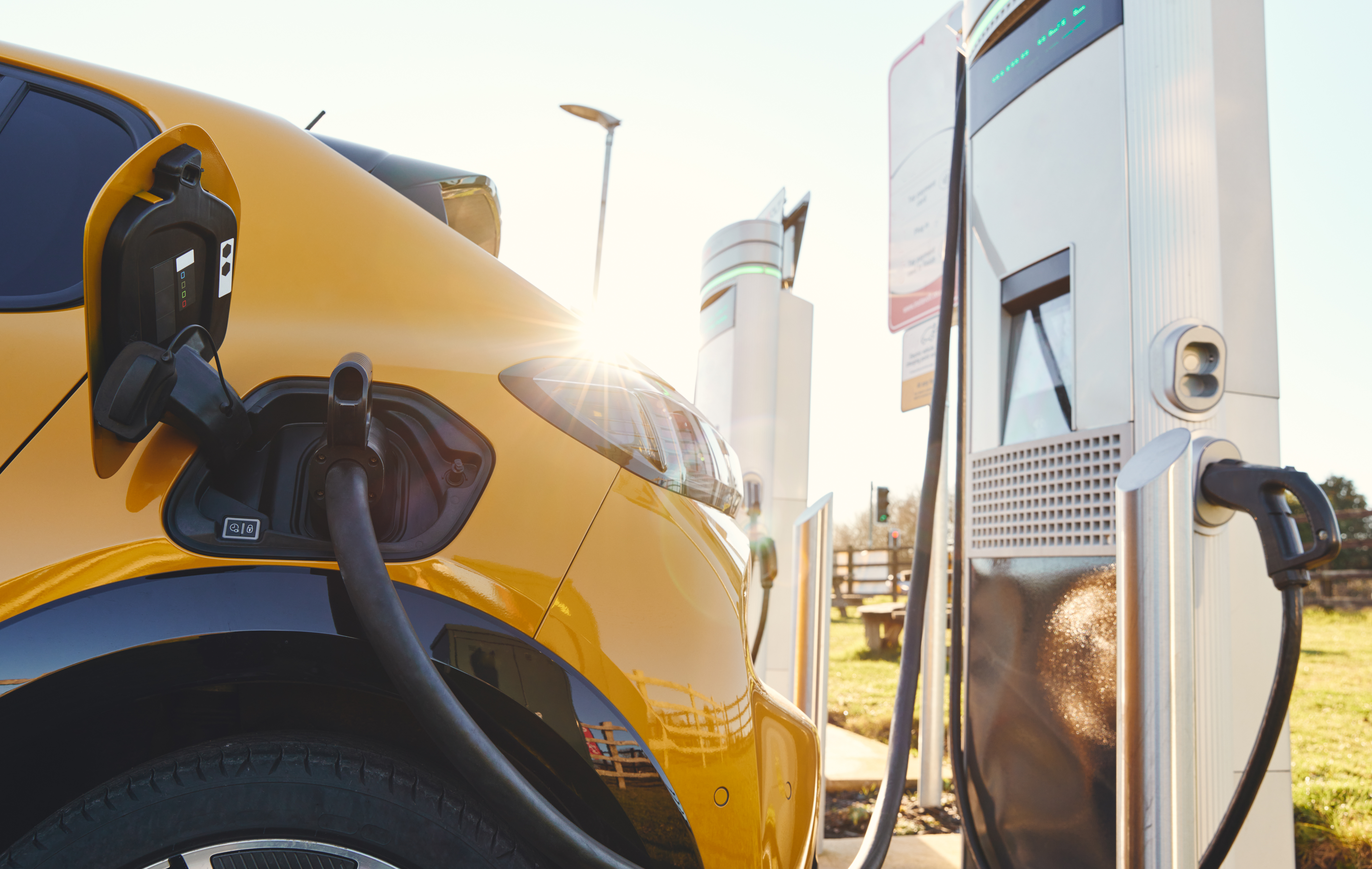 Zu sehen ist ein gelbes Auto, das an eine DC-Ladestation angeschlossen ist